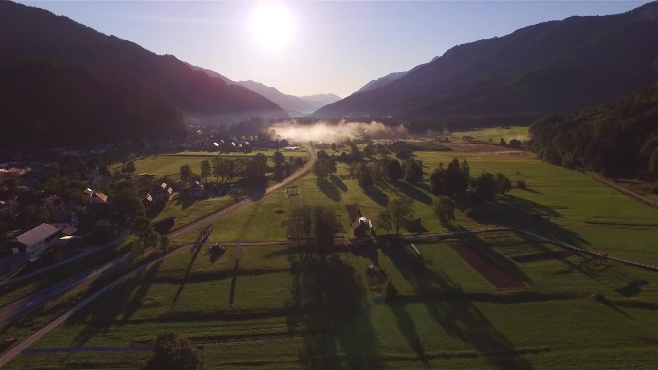 航拍:宁静的村庄和山谷的景色与升起的秋天早晨雾云视频素材