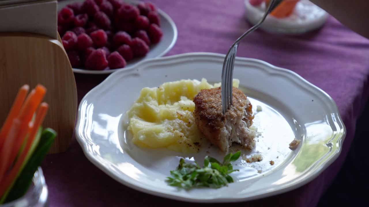 盘子里。孩子吃土豆泥和肉排。视频素材