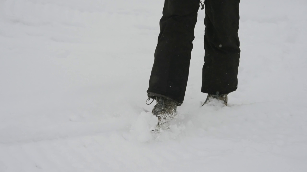 低角度拍摄徒步旅行者在雪地上行走的慢动作视频素材