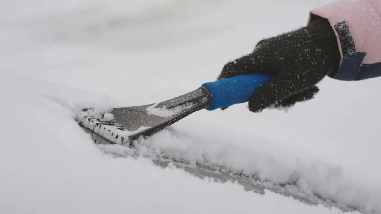 特写的人清洗汽车挡风玻璃从雪，电影慢动作视频素材