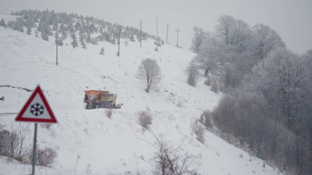 服务铲雪车清除山上滑雪场积雪覆盖的道路后，冬季暴风雪大雪，慢动作视频素材