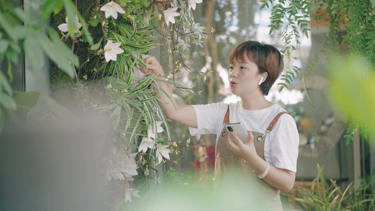 年轻的亚裔女性小企业主在花店工作视频素材