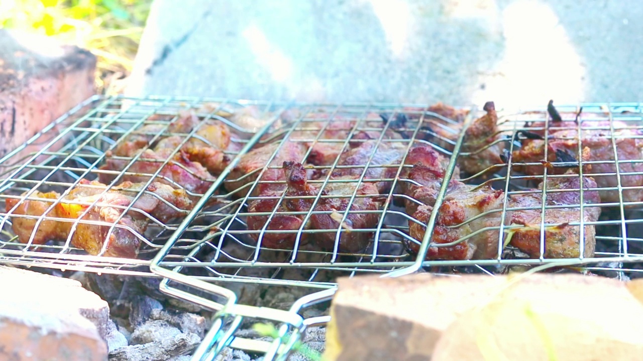 烤肉在网里烤着，冒着烟，慢动作视频下载