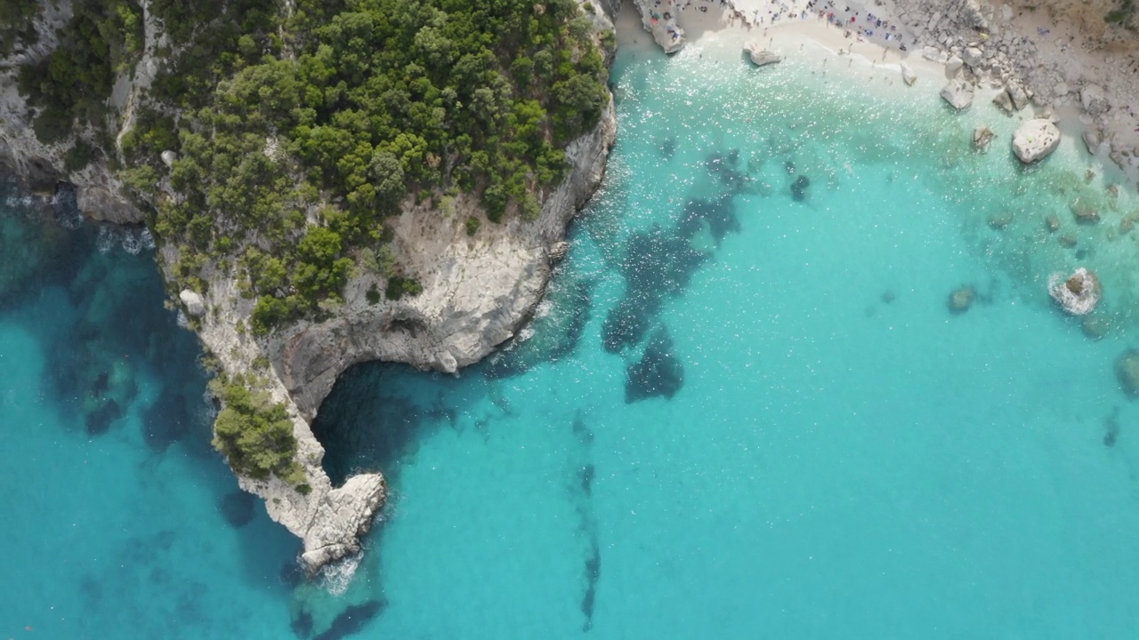 飞越海洞和碧蓝碧绿的水面俯瞰。cpncept旅行。夏日海景的鸟瞰图。意大利撒丁岛视频下载