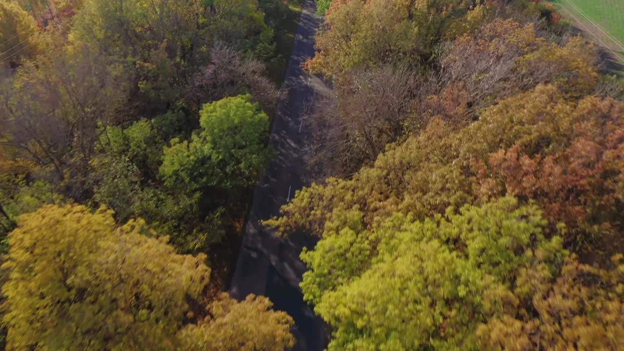 一辆孤零零的白色卡车行驶在田野环绕的高速公路上的鸟瞰图。视频下载