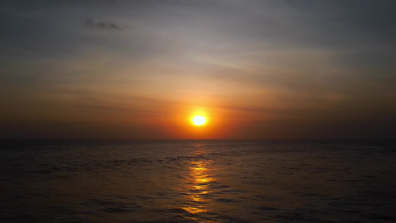 从无人机飞过波涛汹涌的海面上看到的景象，以及水面上炽热的日落视频素材