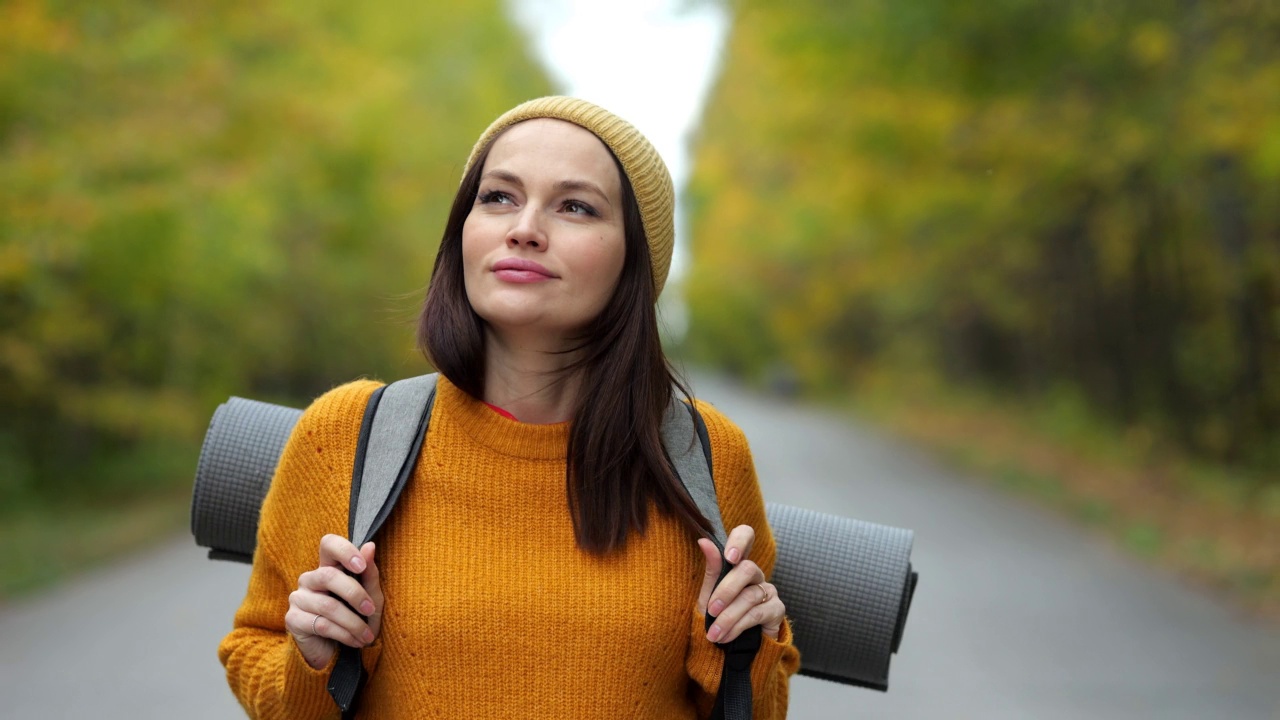 女性徒步旅行者带着兴奋的表情探索秋天的森林视频素材