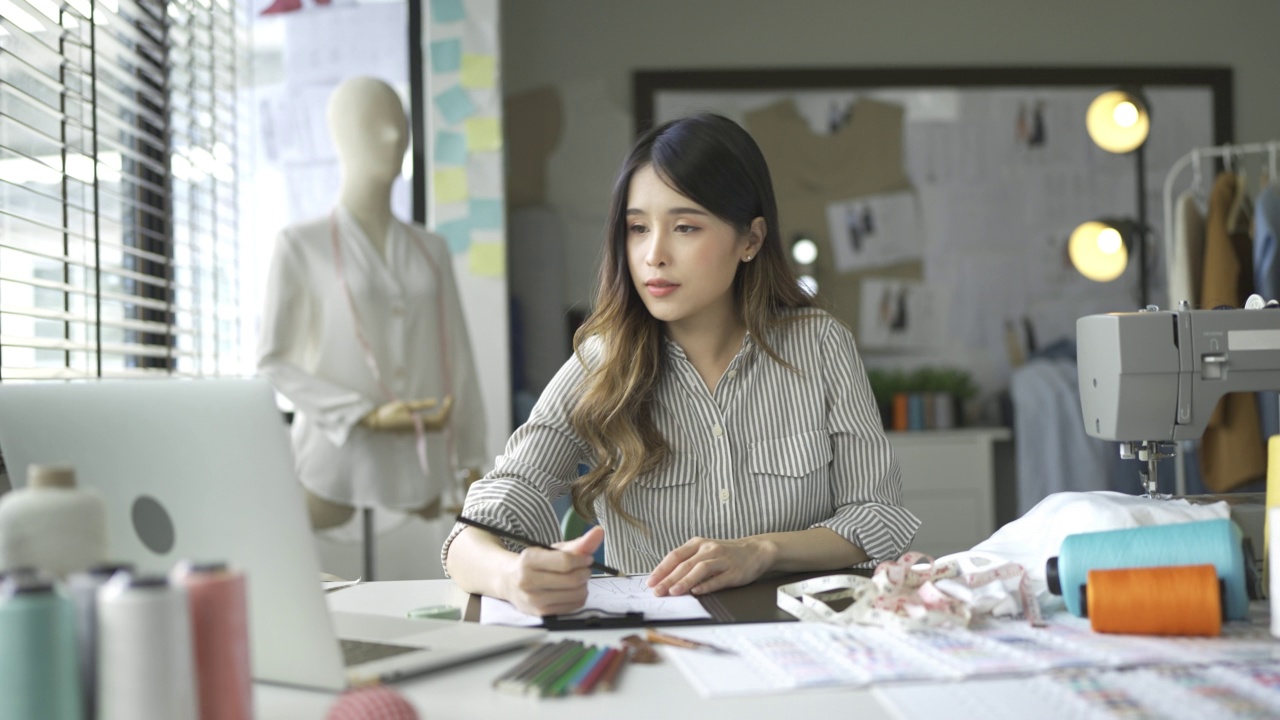 在自己的设计工作室工作的女时装设计师视频素材