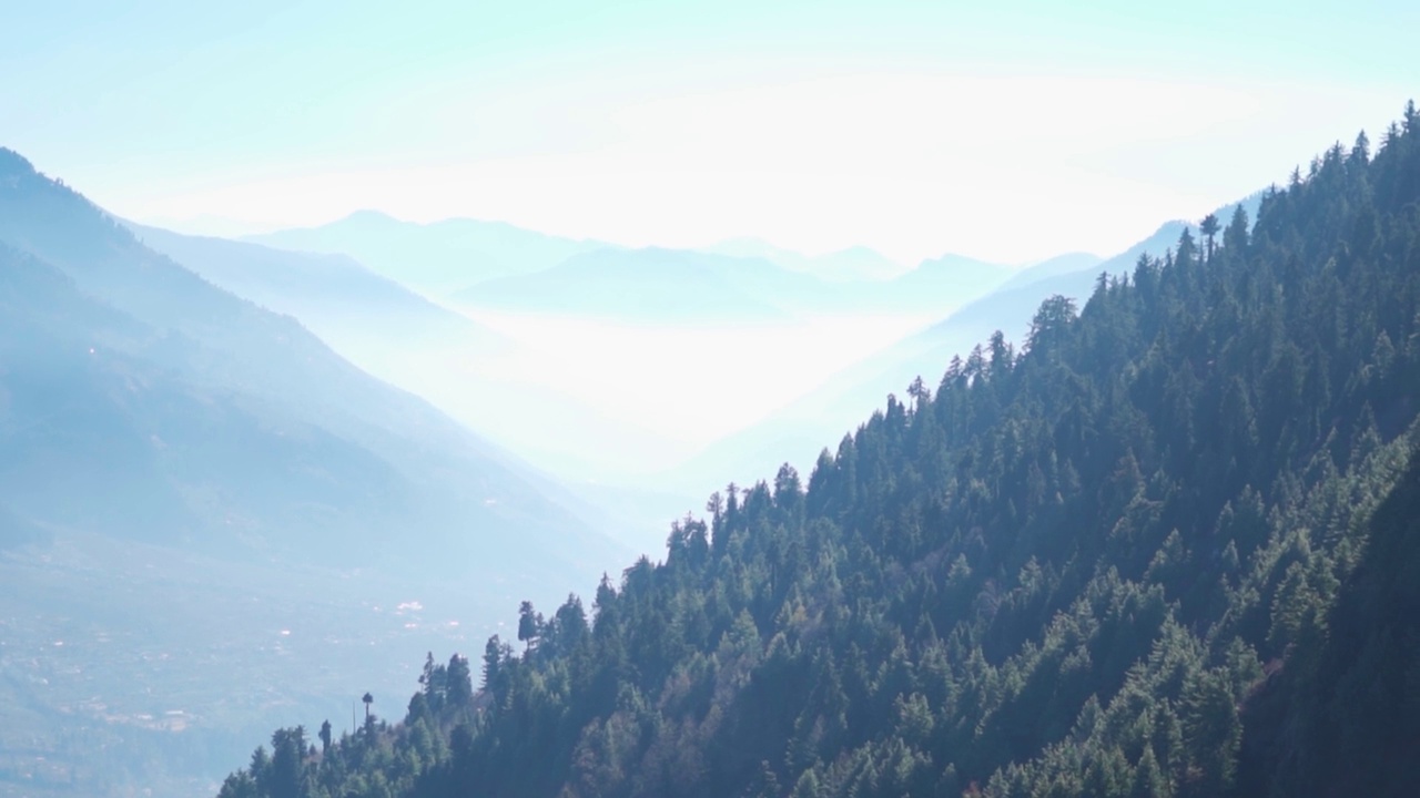 从印度喜马偕尔邦马纳里的山顶上看到的被雾覆盖的山脉景观。山脉中的晨雾。自然背景。雾笼罩着群山视频素材