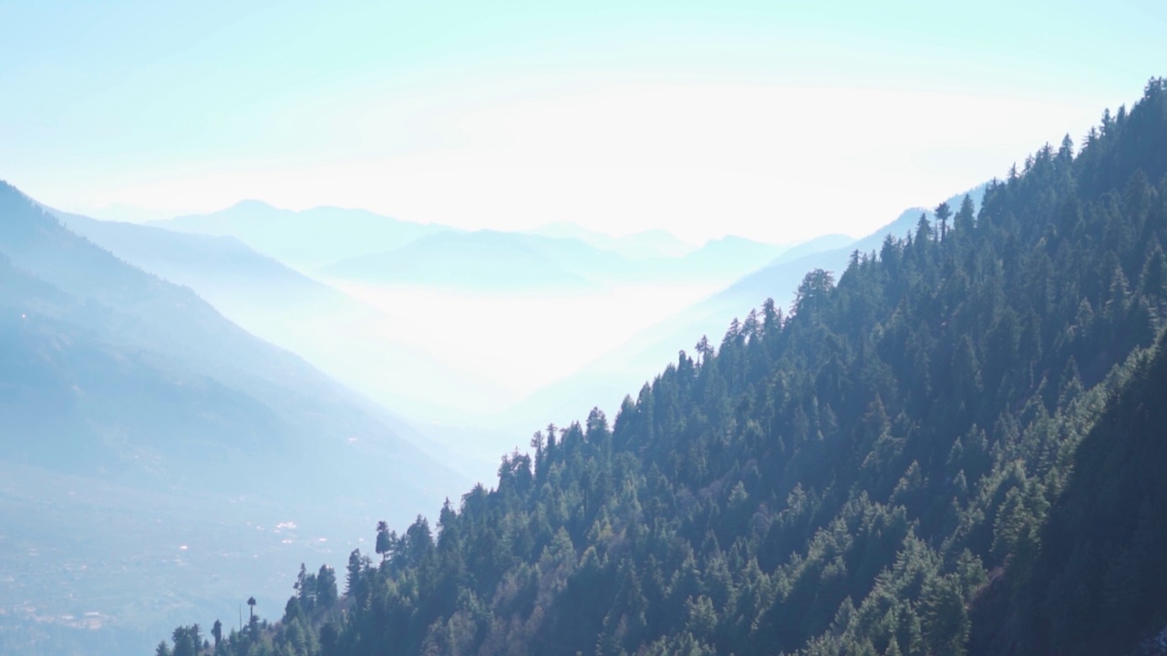 从印度喜马偕尔邦马纳里的山顶上看到的被雾覆盖的山脉景观。山脉中的晨雾。自然背景。雾笼罩着群山视频素材