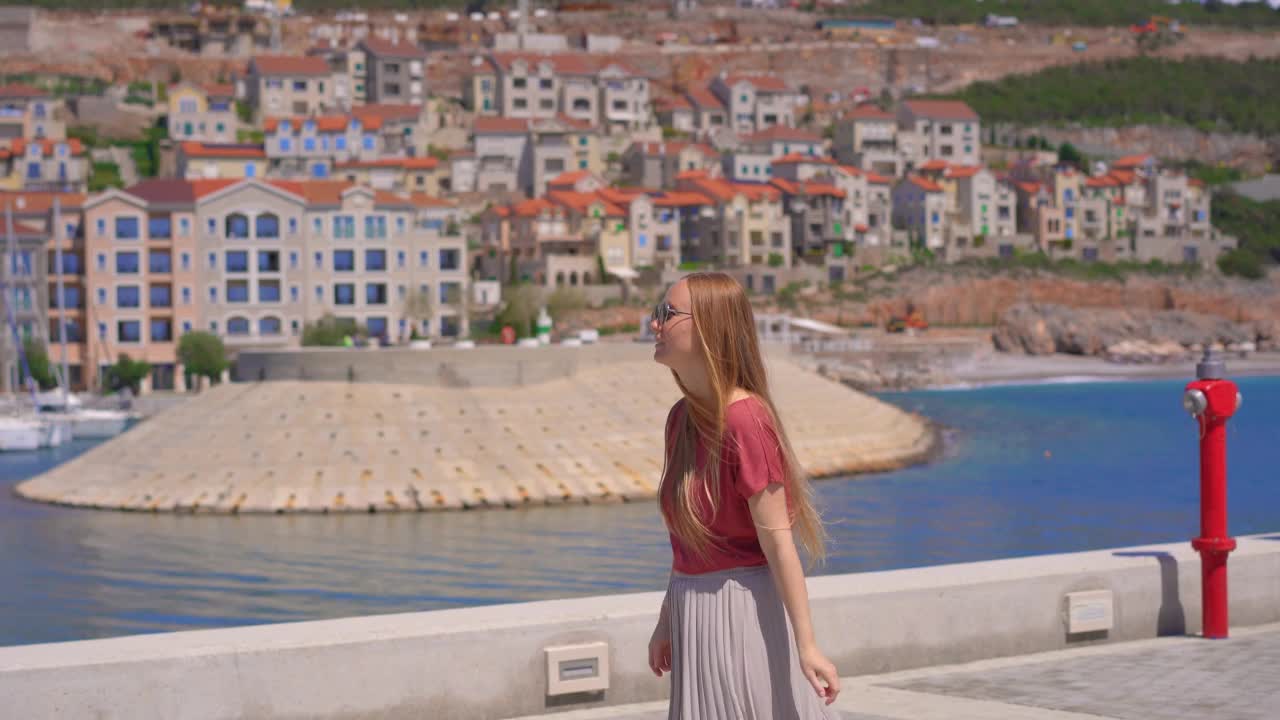 一位年轻女子正走在卢斯蒂卡海湾码头的码头上。前往黑山视频素材