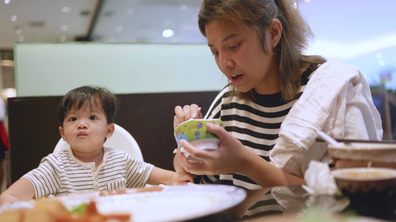 快乐的亚洲妈妈和小男孩在suki餐厅吃饭。视频素材