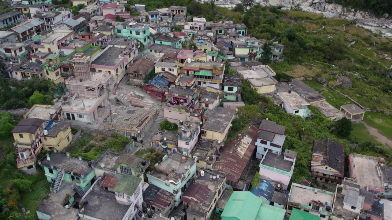 在印度北阿坎德邦的Chamoli地区，沿着冰川河流的喜马拉雅村庄的4K空中无人机库存视频视频素材