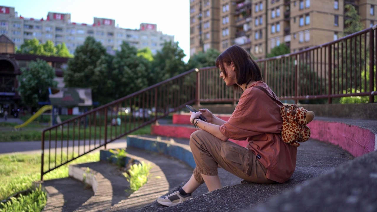 年轻女子在户外使用智能手机视频素材