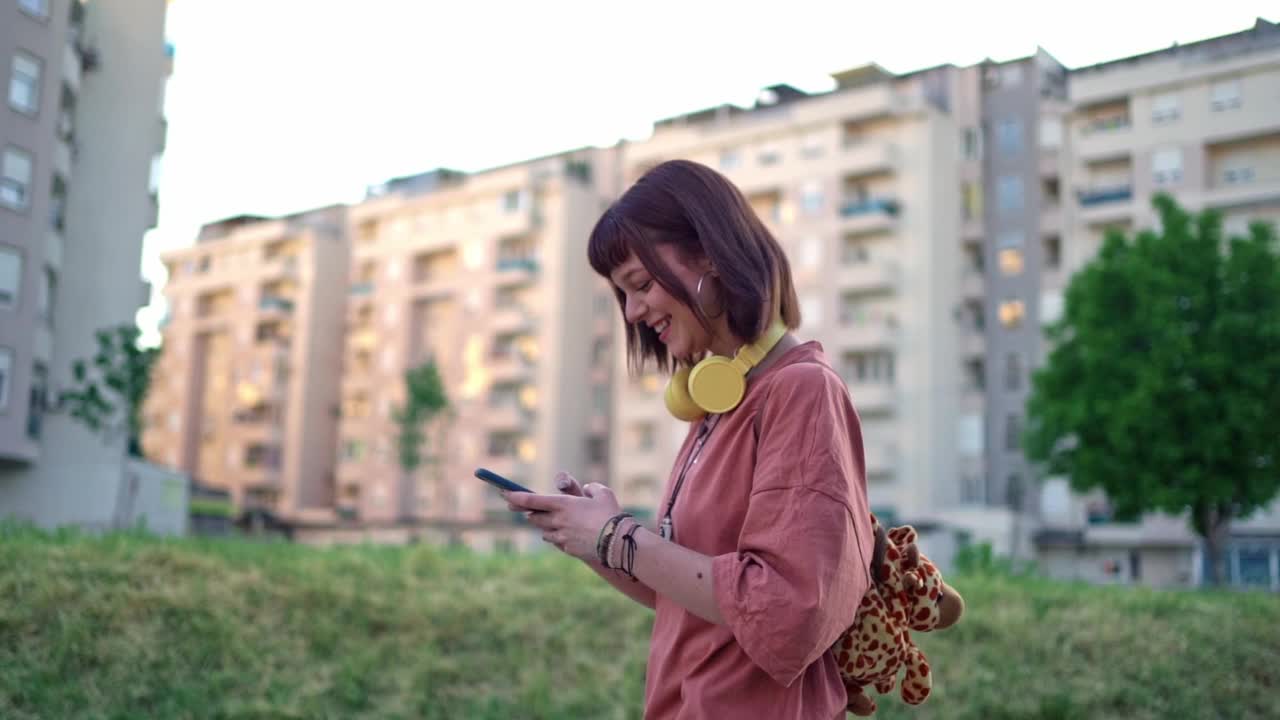 一名妇女在城市中走路时使用手机视频素材