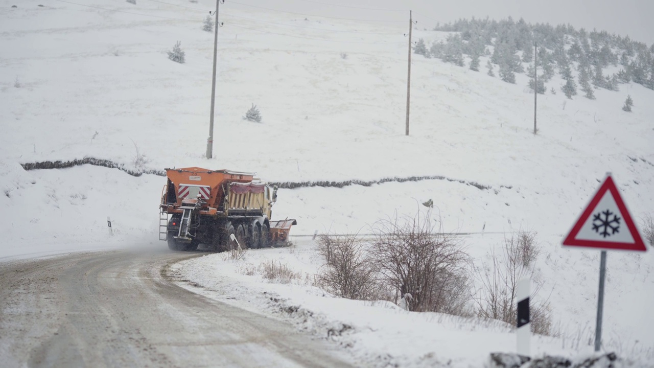 服务铲雪车清除雪山雪场积雪覆盖道路后，冬季暴风雪降雪，慢动作视频素材