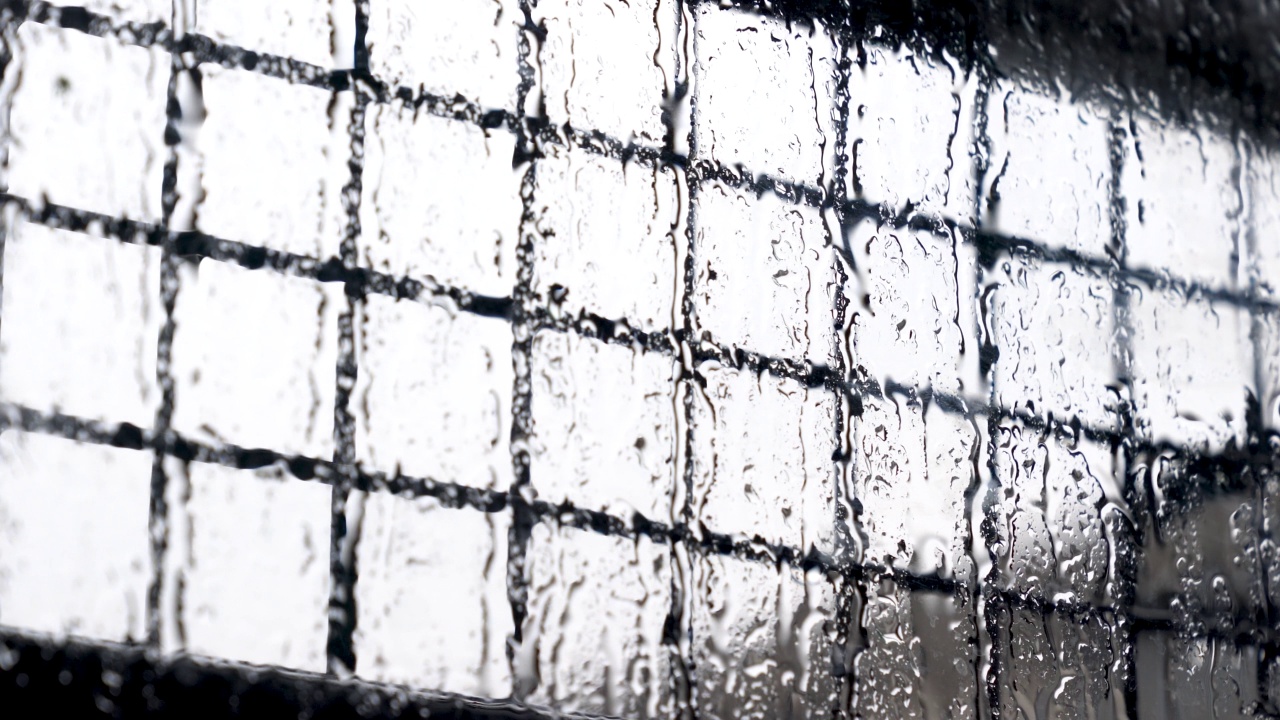 雨点顺着窗沿流下来。外面夏雨滂沱。强风和雨滴落在阳台的玻璃窗上。视频素材