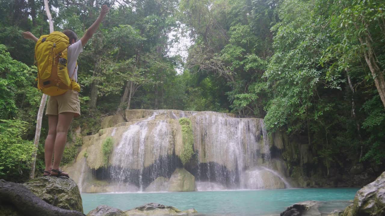 一个亚洲少女踏上了在泰国丛林中发现绿松石瀑布的旅程。视频素材