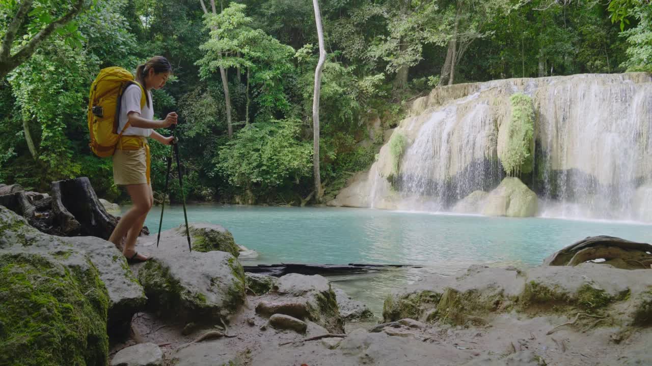 一个亚洲少女踏上了在泰国丛林中发现绿松石瀑布的旅程。视频素材