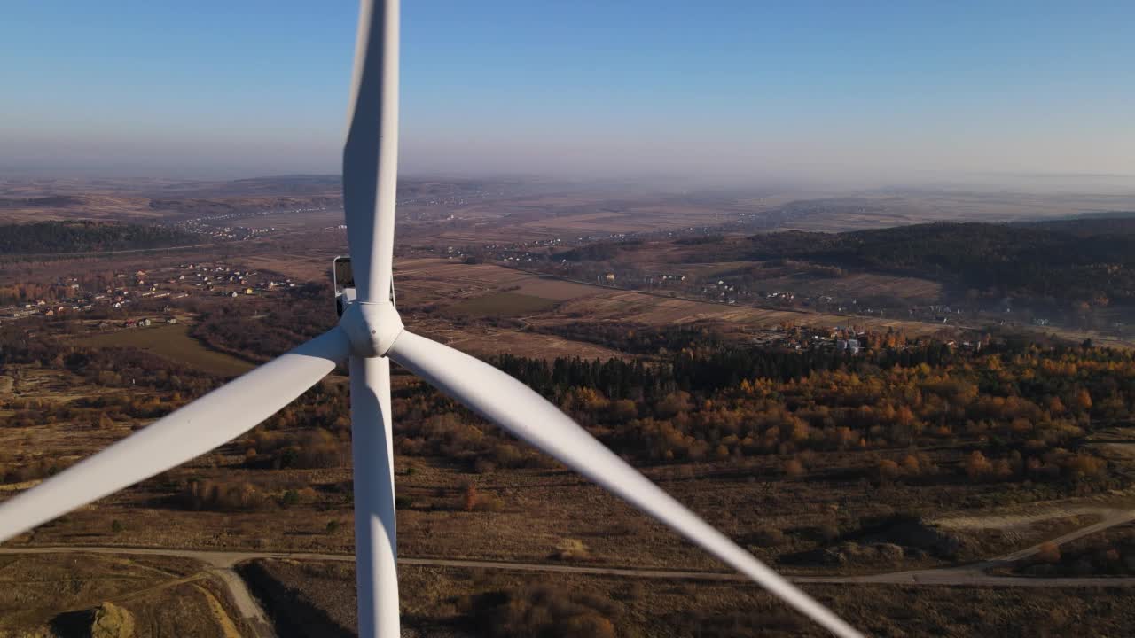 空中特写的风力涡轮机与旋转叶片在全景背景下，无人机向后飞行视频素材