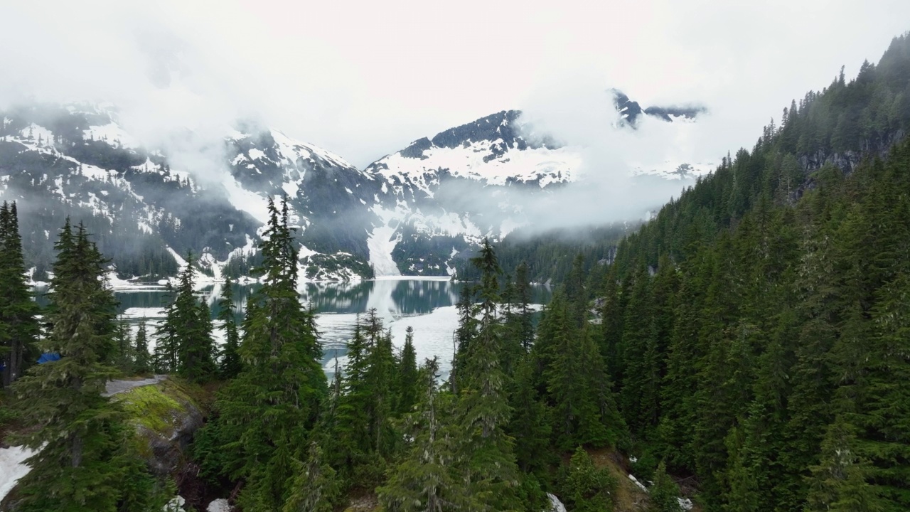 融化的冰雪包围着雾气弥漫的山湖视频素材