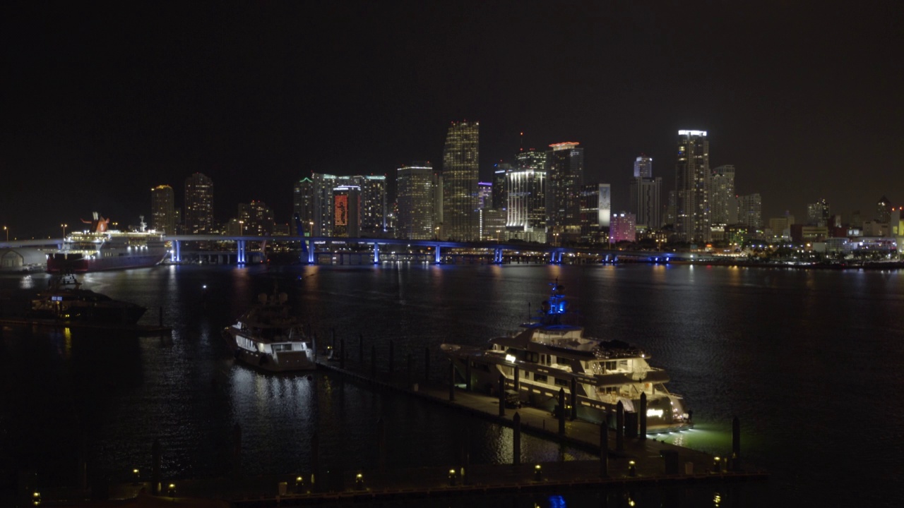 空中封锁拍摄的客船在夜晚在现代城市的港口-迈阿密，佛罗里达州视频素材