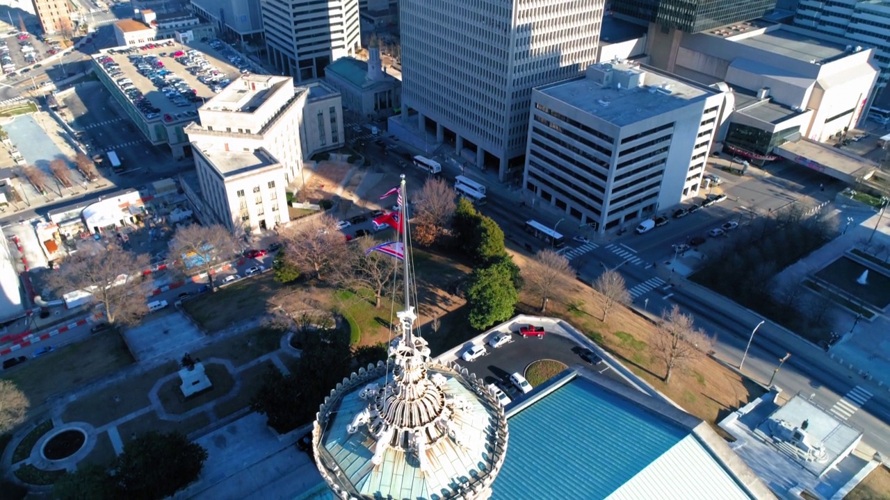 在阳光明媚的日子里，从空中向下倾斜拍摄的居住城市政府大楼上的国旗——田纳西州的纳什维尔视频素材