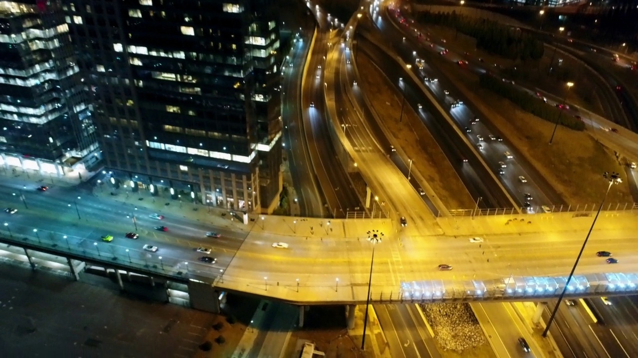 空中倾斜拍摄的汽车在桥路上移动的现代建筑在夜晚的城市照明-亚特兰大，乔治亚州视频素材