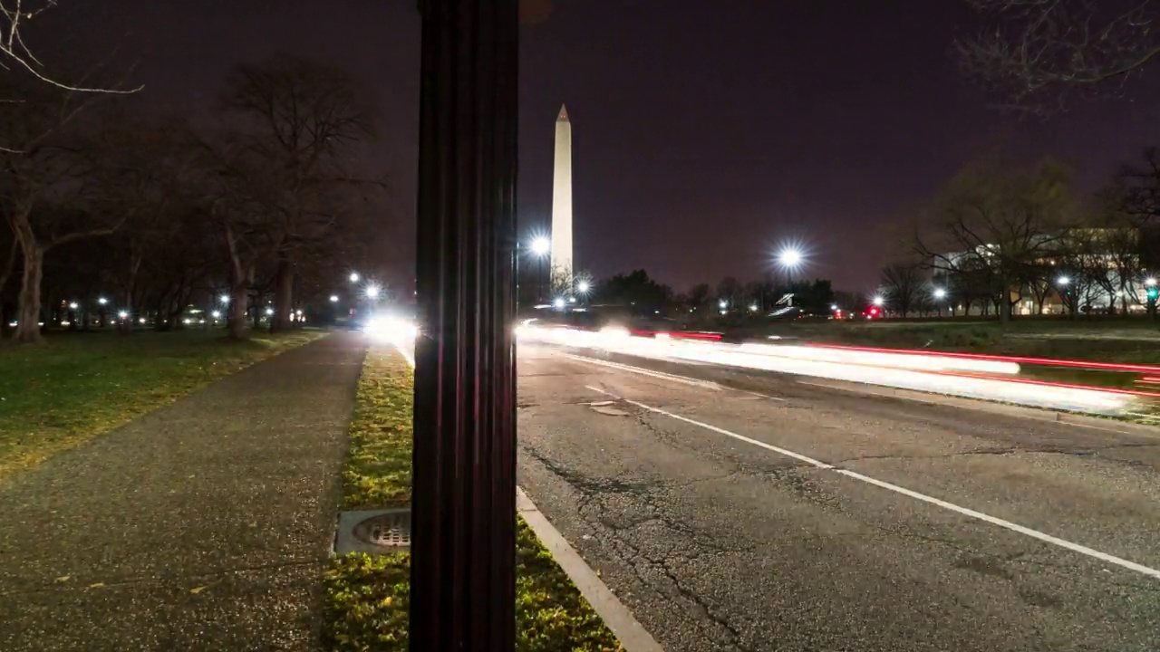 著名的方尖碑形建筑的平移时间推移拍摄的汽车行驶在道路上的夜晚-华盛顿，哥伦比亚特区视频素材