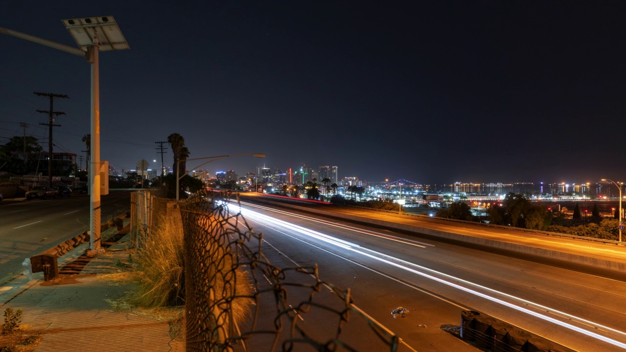 夜间在城市道路上行驶的车辆的长时间曝光延时锁定镜头——加利福尼亚州圣地亚哥视频素材