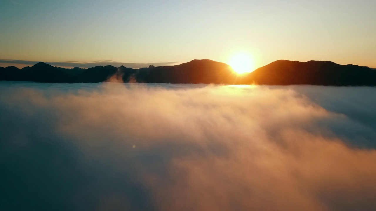 空中拍摄的日出时的岩层，无人机向前飞越蓬松的云景-特罗姆瑟，挪威视频素材