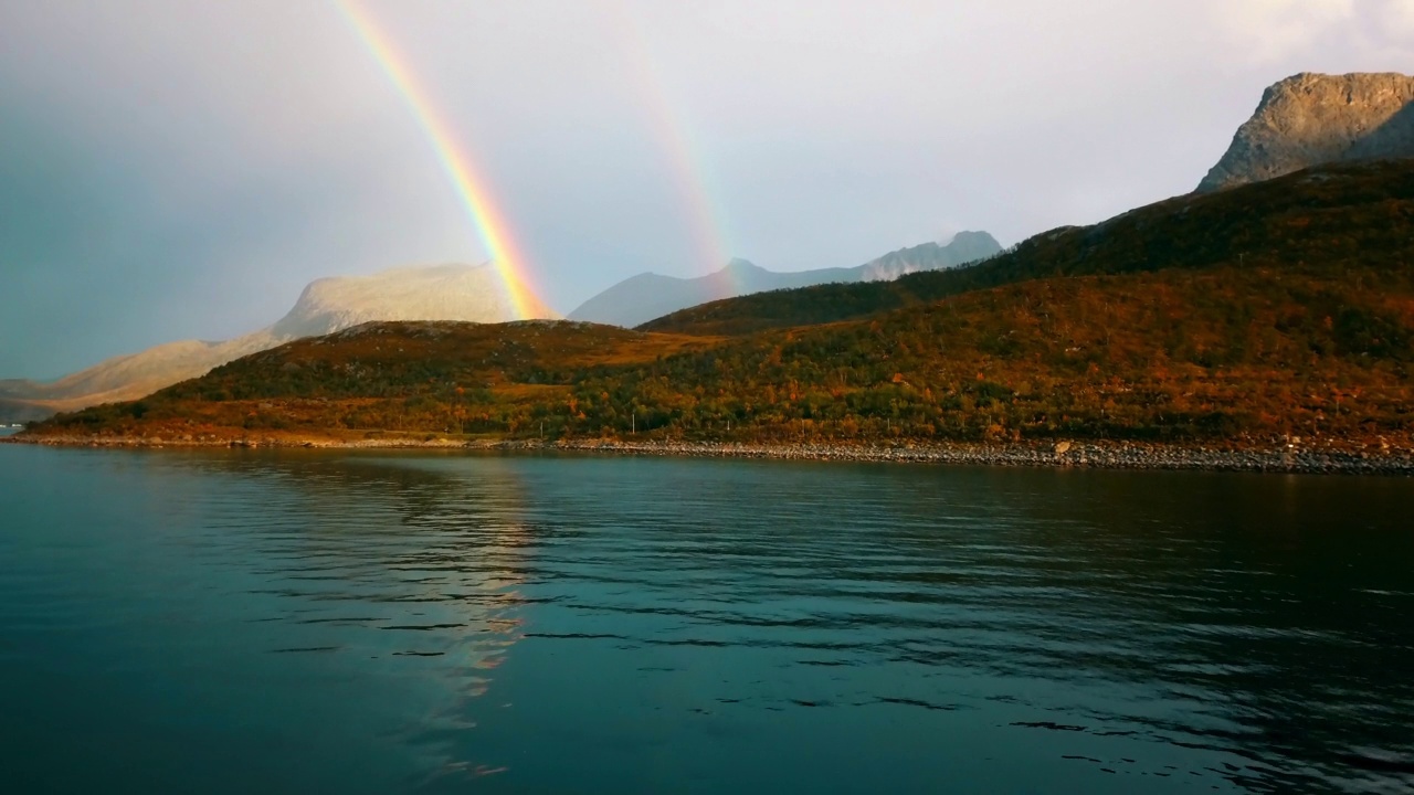 空中的彩虹风景由岩层，无人机向前飞越海面-特罗姆瑟，挪威视频素材