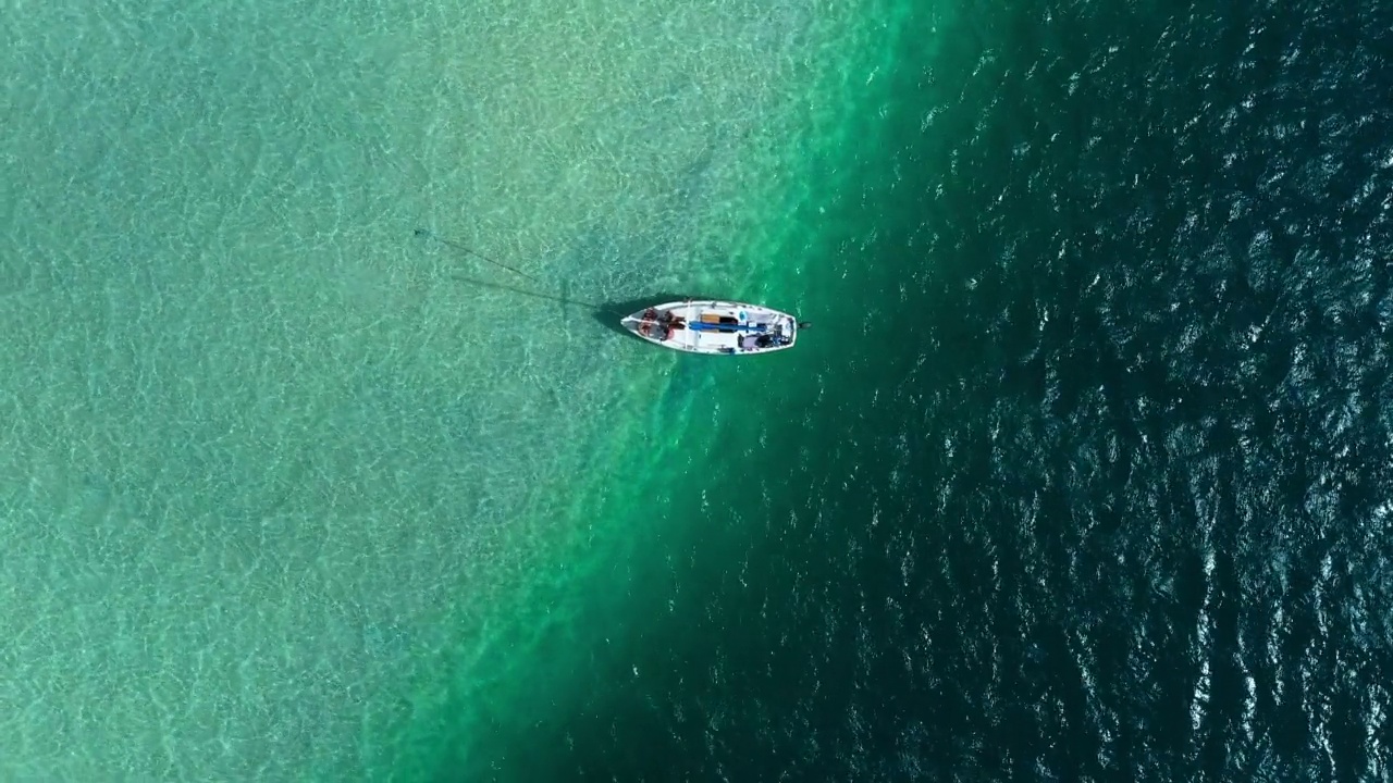 空中拍摄的游客在绿松石海上的航海船航行-夏威夷考艾岛视频素材