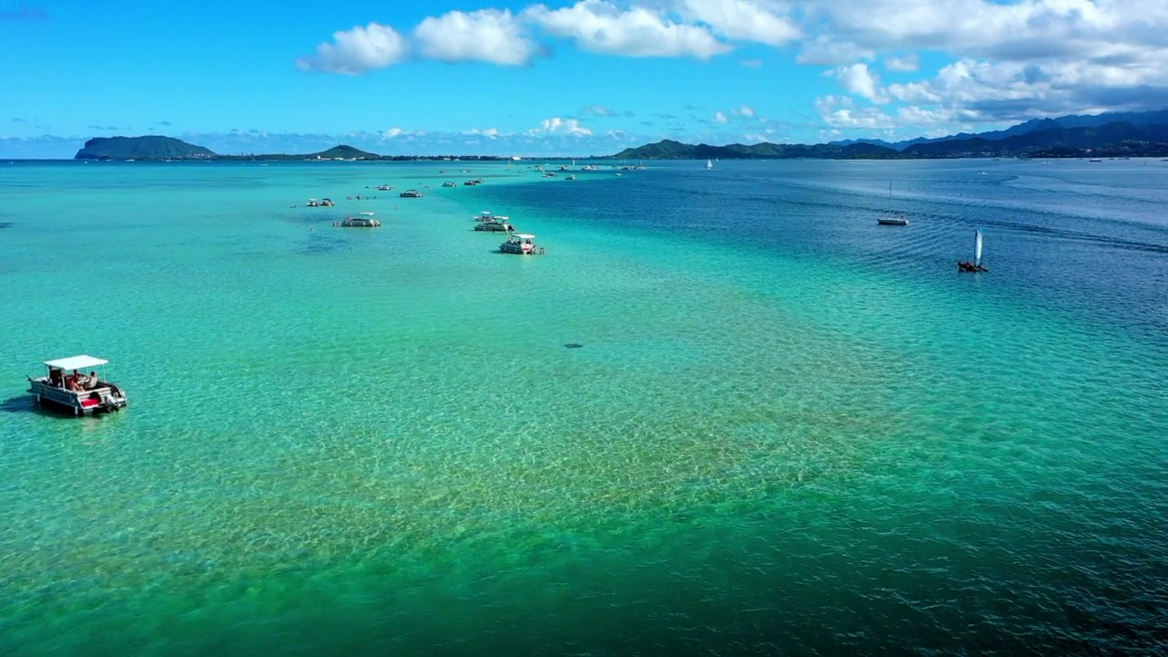 航拍向前航行船只漂浮在蓝绿色的海面下多云的天空-瓦胡岛，夏威夷视频素材