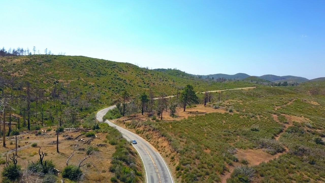 航拍的汽车在森林的道路上移动，无人机向下飞过景观-南加州，加利福尼亚州视频素材