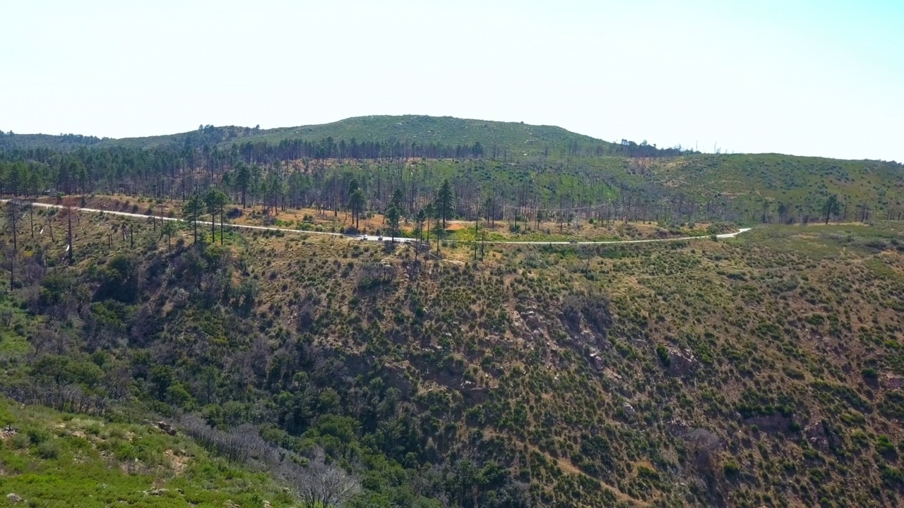 空中拍摄的汽车停在森林的道路上，无人机向后飞过天然山丘-南加州，加利福尼亚州视频素材