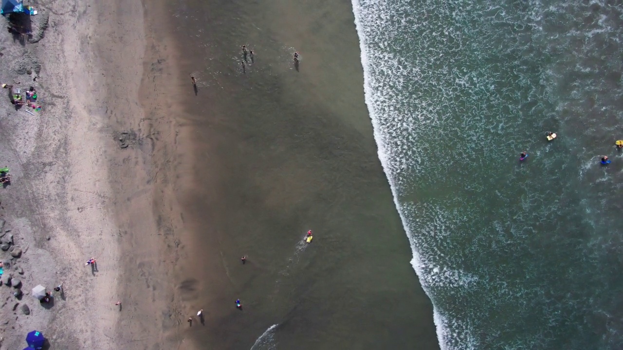 加利福尼亚州海岸的太平洋海滩的鸟瞰图，海浪沿着海滩撞击的高角度视图，海滩的直下无人机视图视频素材