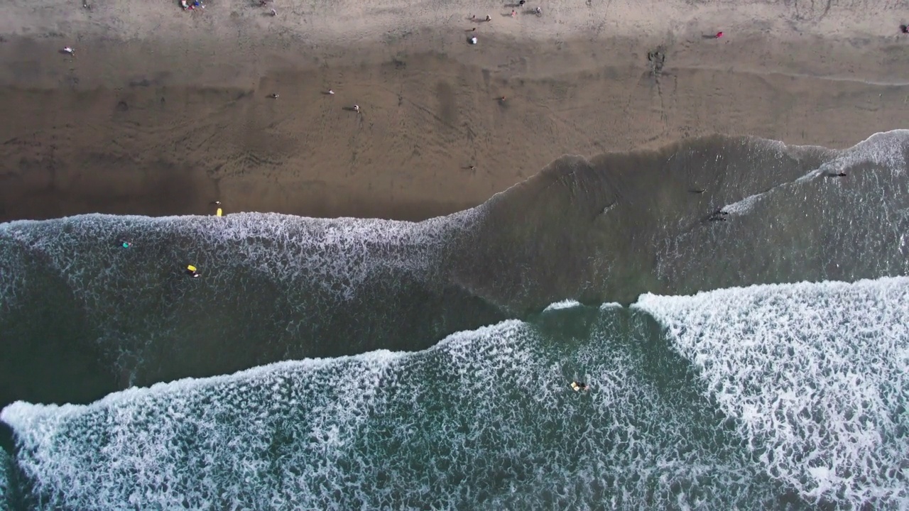 加利福尼亚州海岸的太平洋海滩的鸟瞰图，海浪沿着海滩撞击的高角度视图，海滩的直下无人机视图视频素材