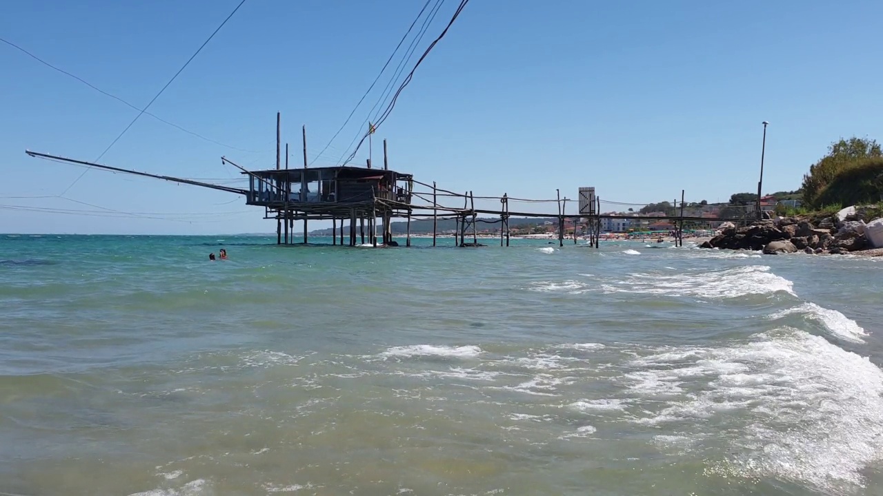 游客在costa dei trabocchi的海中游泳，背景是trabucco或trabucco视频素材