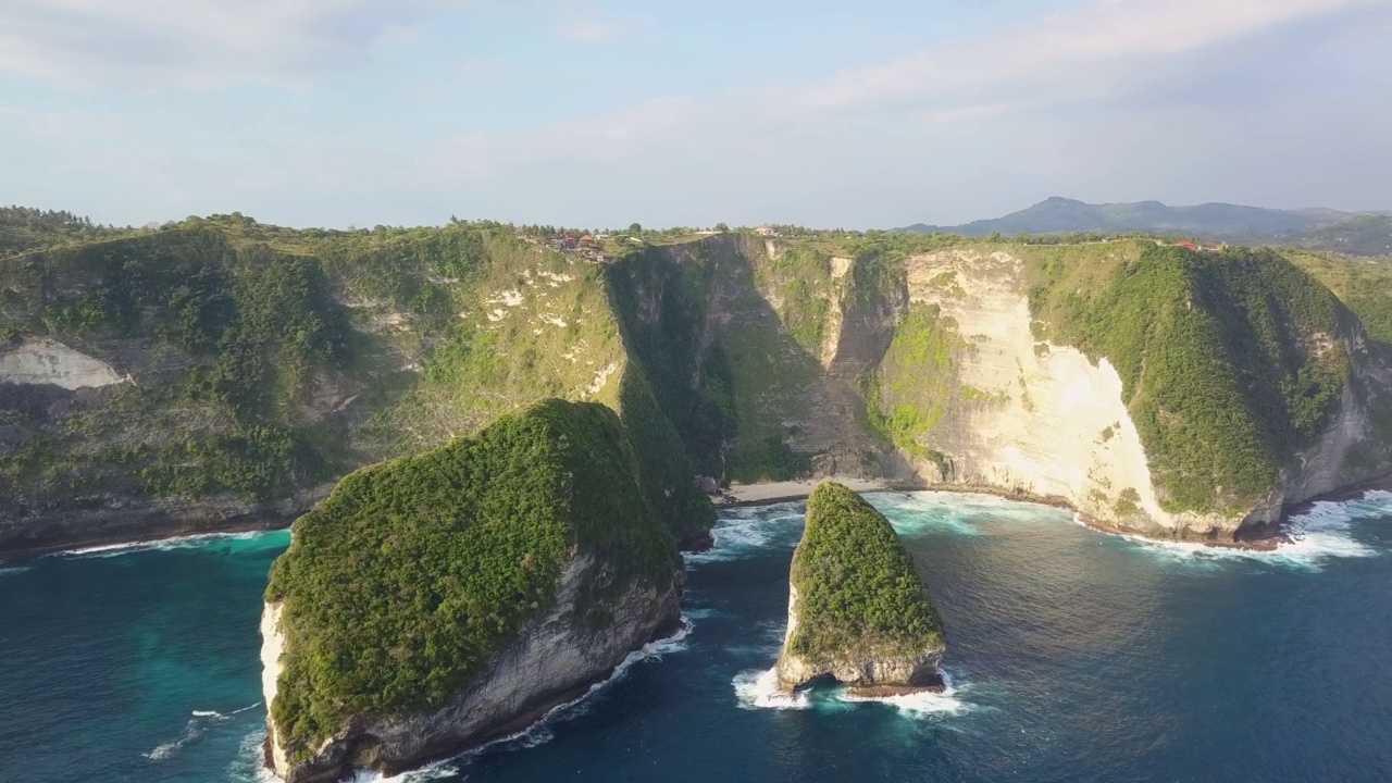 引人注目的无人机拍摄的著名的克林金海滩，又名霸王龙海滩，在印度尼西亚巴厘岛的努沙佩尼达。它以惊人的悬崖而闻名。用旋转动作拍摄。视频素材