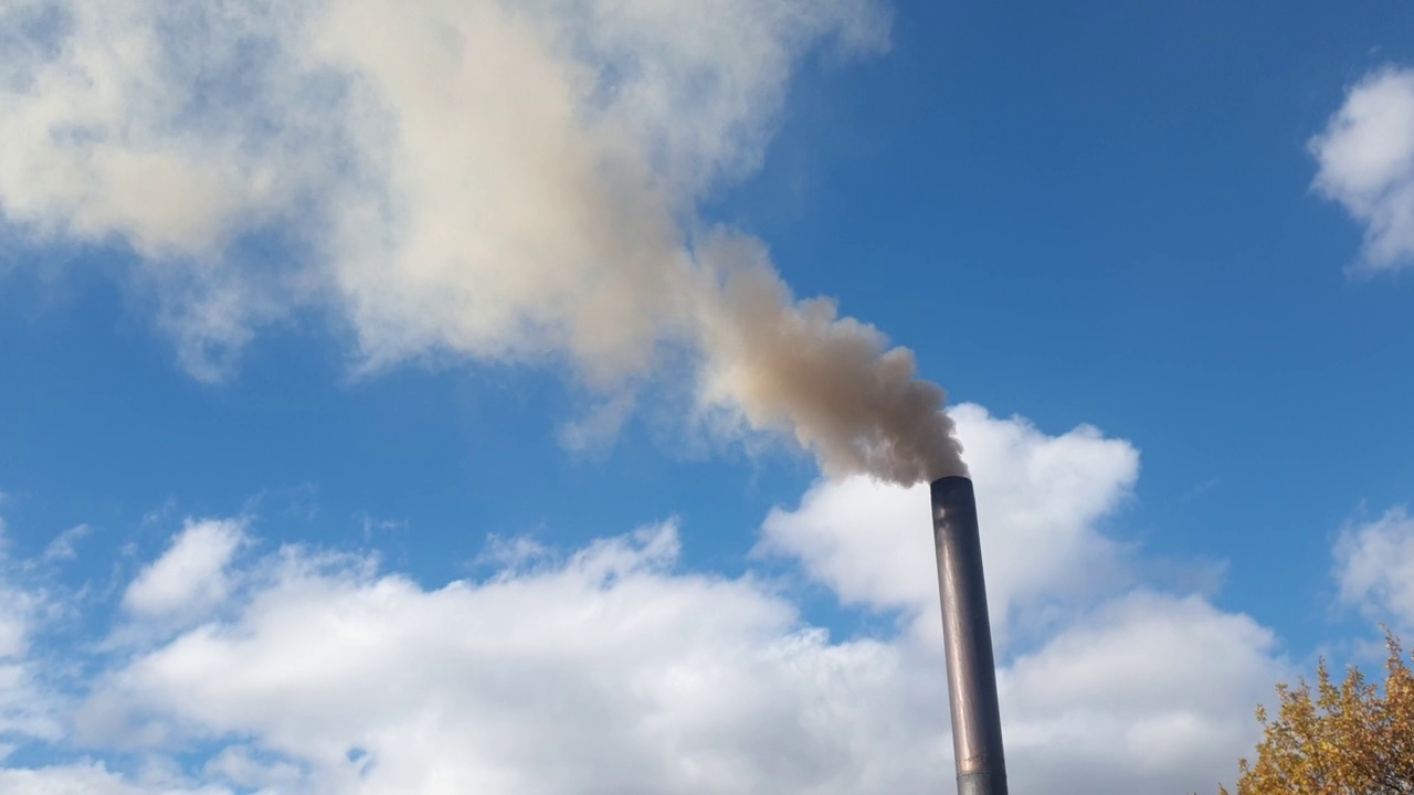 烟囱冒出的烟对着天空，用煤取暖的小屋，环境污染和能源危机视频素材