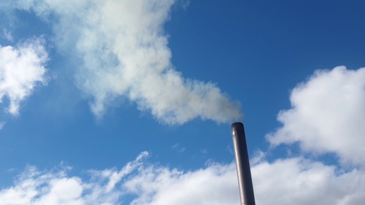 烟囱冒出的烟对着天空，用煤取暖的小屋，环境污染和能源危机视频素材