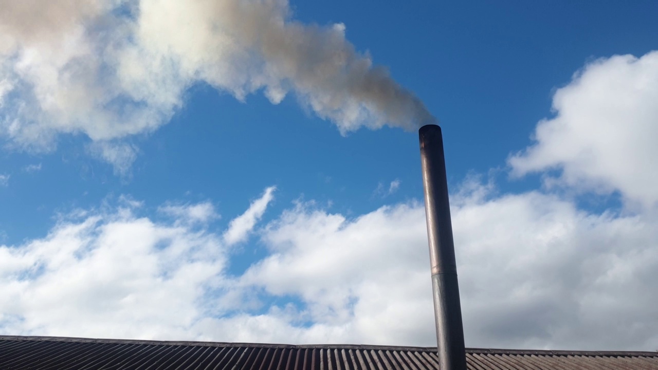 烟囱冒出的烟对着天空，用煤取暖的小屋，环境污染和能源危机视频素材