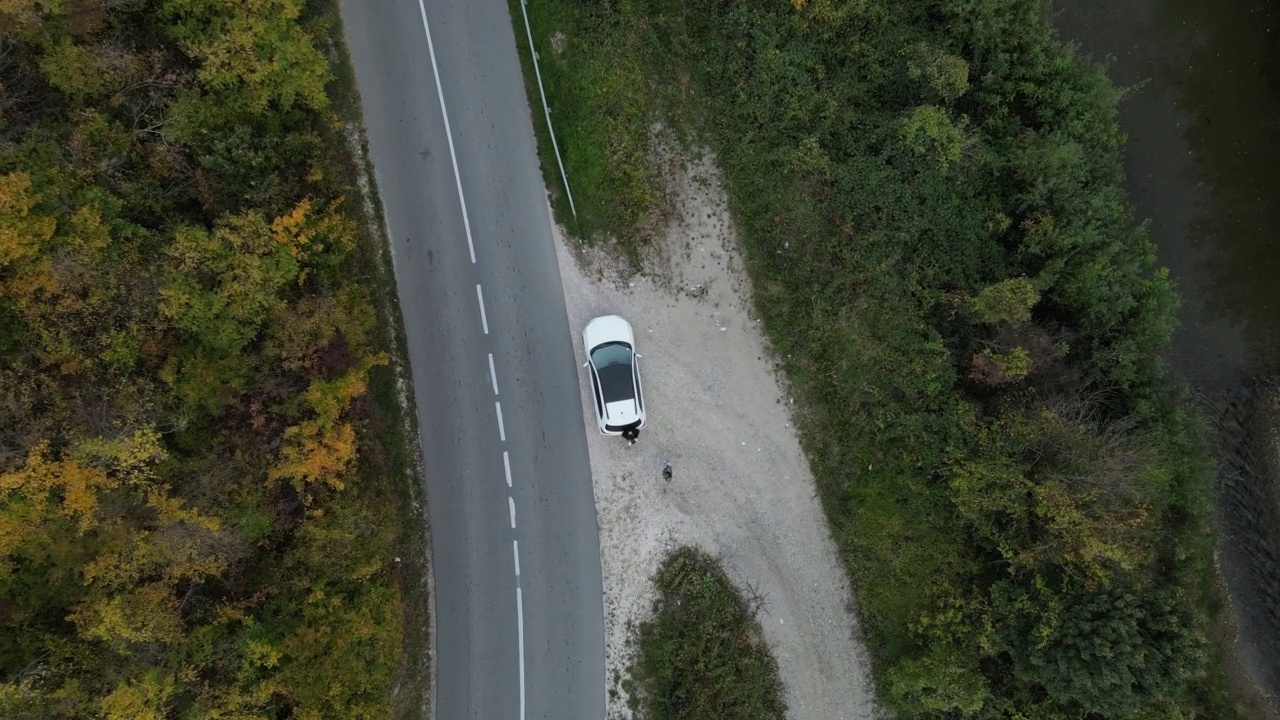 汽车行驶在道路上，在秋天的日子重型车辆运输旅行汽车驾驶假期的概念上，沥青自上而下的空中无人机视图视频素材