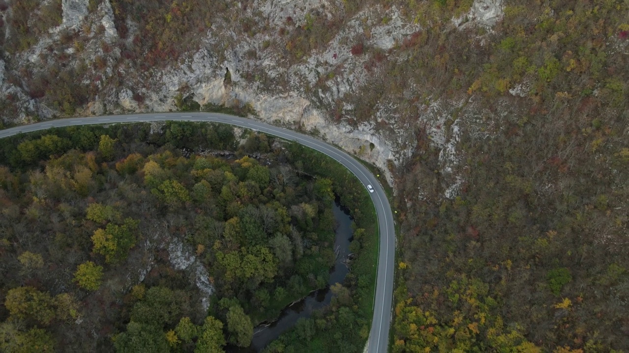 汽车行驶在道路上，在秋天的日子重型车辆运输旅行汽车驾驶假期的概念上，沥青自上而下的空中无人机视图视频素材