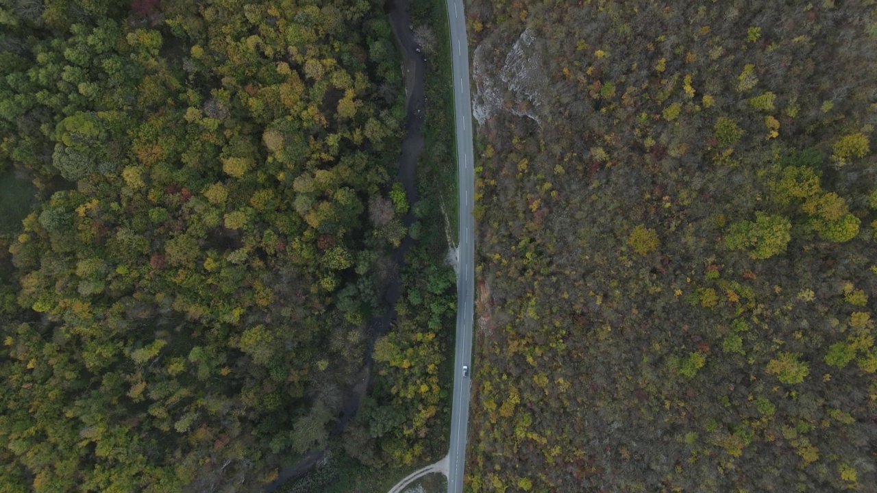 汽车行驶在道路上，在秋天的日子重型车辆运输旅行汽车驾驶假期的概念上，沥青自上而下的空中无人机视图视频素材