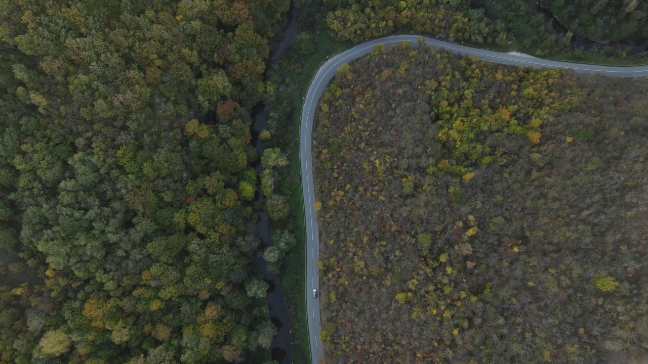 汽车行驶在道路上，在秋天的日子重型车辆运输旅行汽车驾驶假期的概念上，沥青自上而下的空中无人机视图视频素材