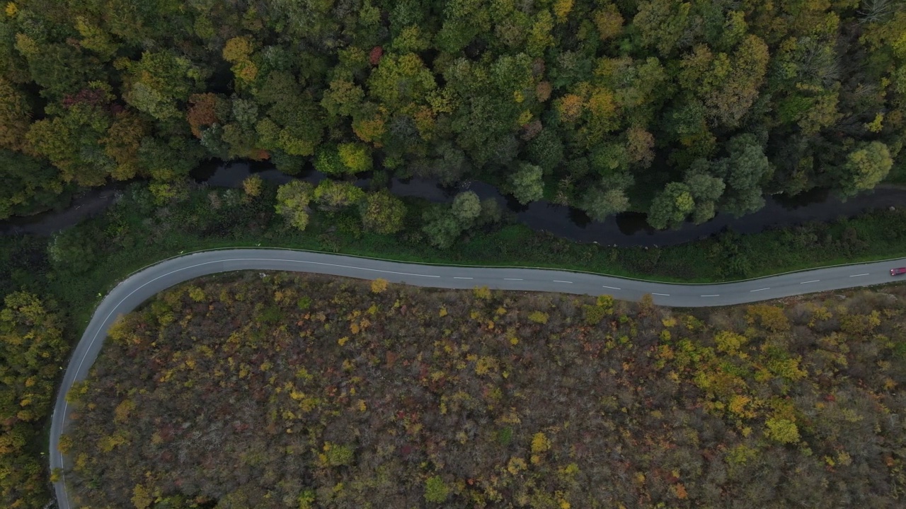 汽车行驶在道路上，在秋天的日子重型车辆运输旅行汽车驾驶假期的概念上，沥青自上而下的空中无人机视图视频素材