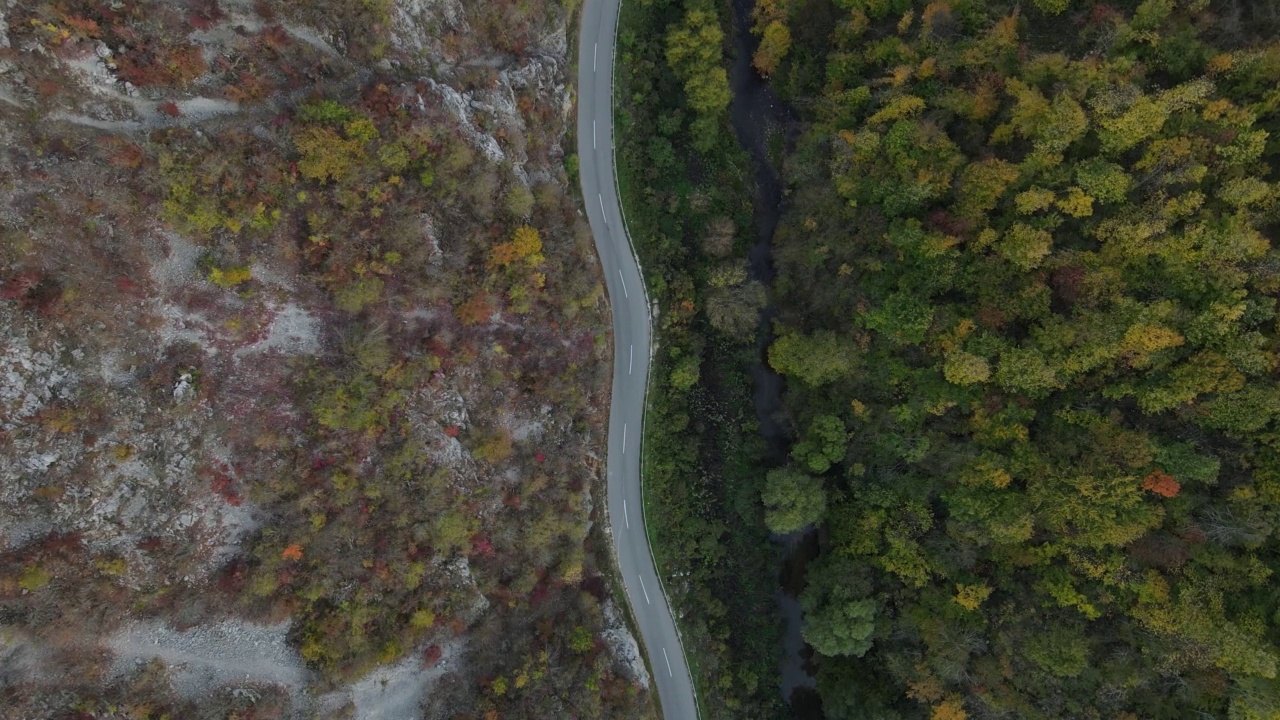 汽车行驶在道路上，在秋天的日子重型车辆运输旅行汽车驾驶假期的概念上，沥青自上而下的空中无人机视图视频素材