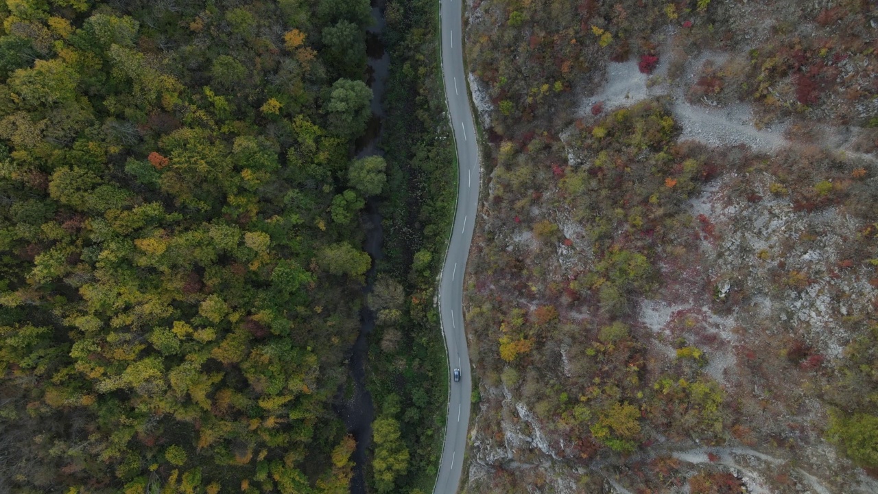 汽车行驶在道路上，在秋天的日子重型车辆运输旅行汽车驾驶假期的概念上，沥青自上而下的空中无人机视图视频素材